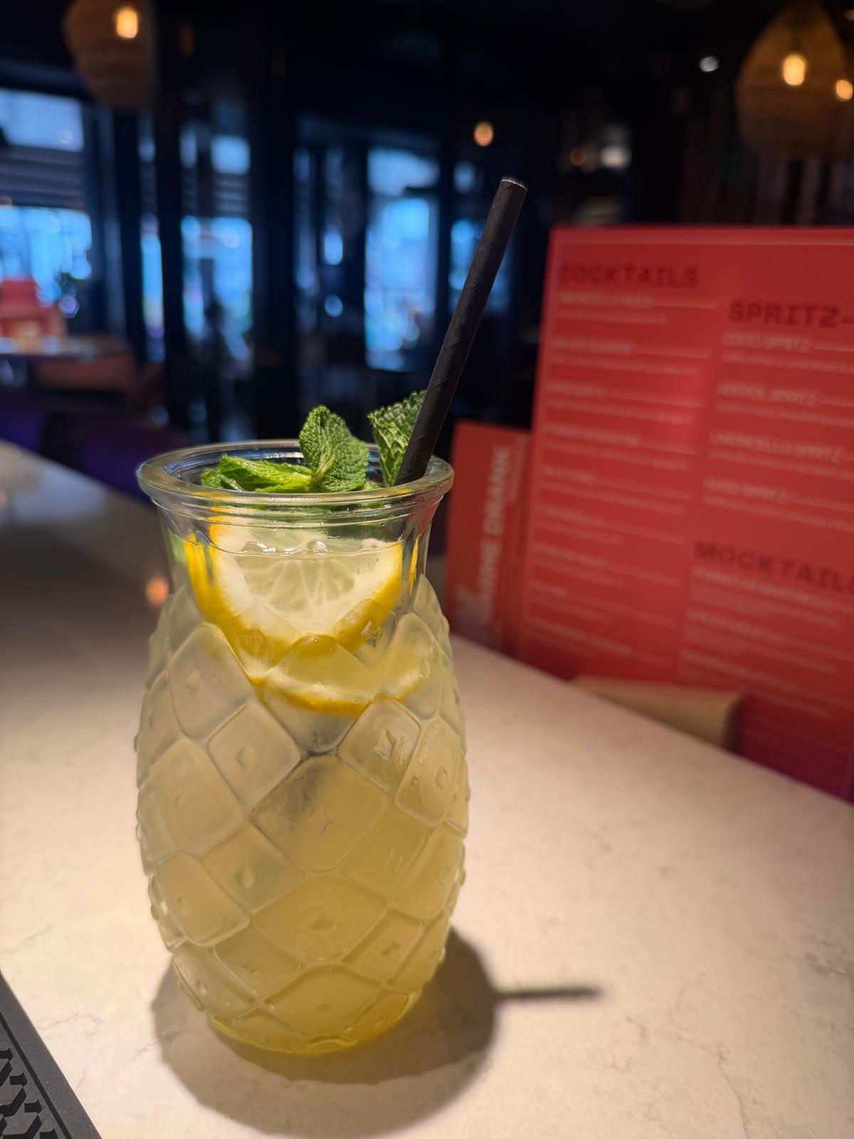 Fles huisgemaakte Sour Bastard citruslimonade met glas op terrastafel