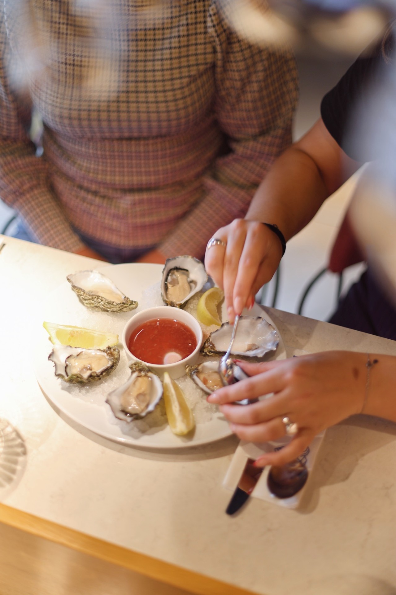 Verse Zeeuwse oesters met citroen en saus aan tafel